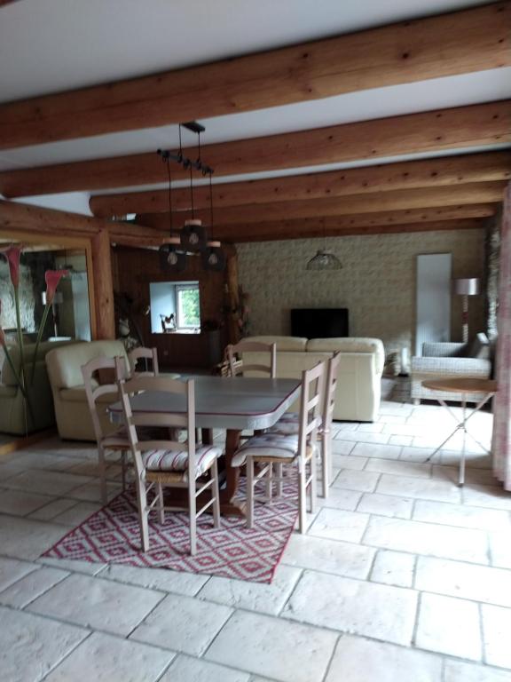 a dining room and living room with a table and chairs at Le fourezon in Saint-Jeures