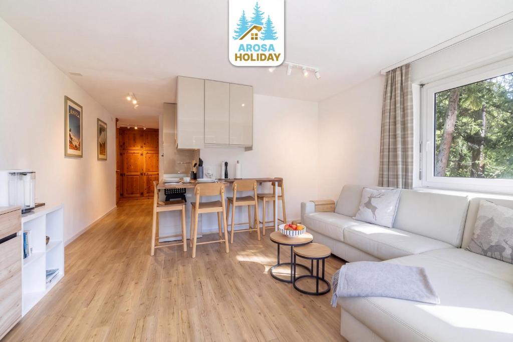 a living room with a couch and a kitchen at Irmella 40 by Arosa Holiday in Arosa