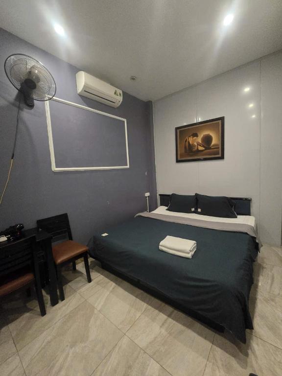 a bedroom with a bed and a desk with a fan at Gia An Hotel in Hanoi