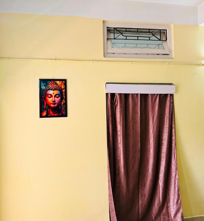a window with a curtain and a picture of a mask at Moon Villa Homestay in Nowgong