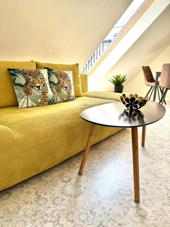 a living room with a yellow couch and a table at Sunny Gym Studio Apartment in Burgas