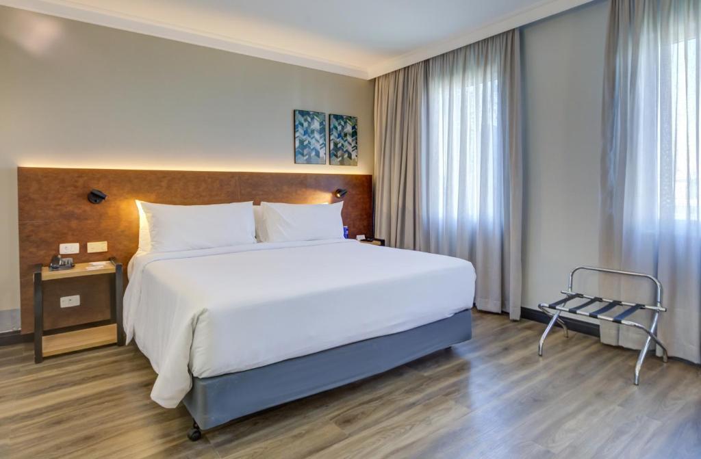 a bedroom with a large white bed and a window at Park Inn by Radisson Berrini in São Paulo