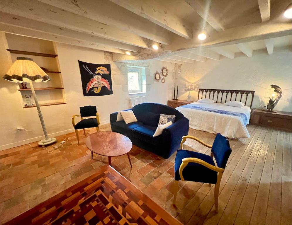 a bedroom with a bed and a couch and a table at La Motelle N 5 in Les Ulmes