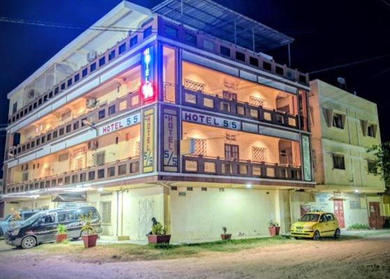 a building with two cars parked in front of it at L'Hotel 5-5 in Mahajanga