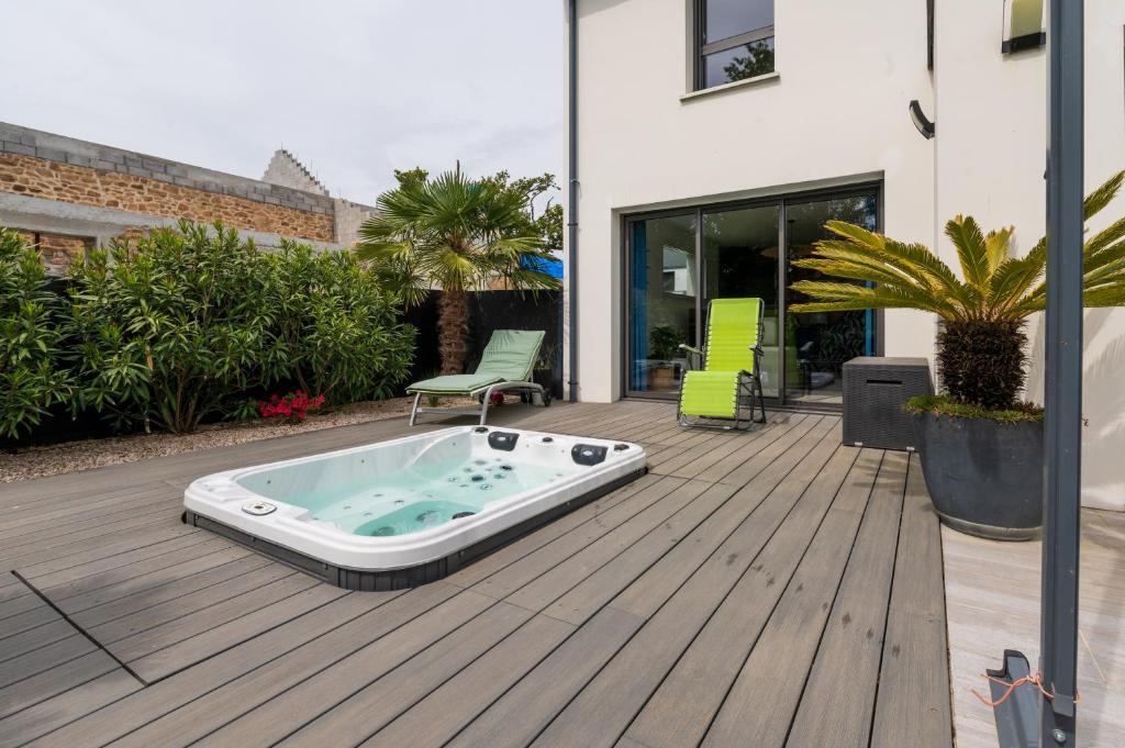 a hot tub sitting on the deck of a house at Chambre d'hôtes reflets du Golfe in Arradon