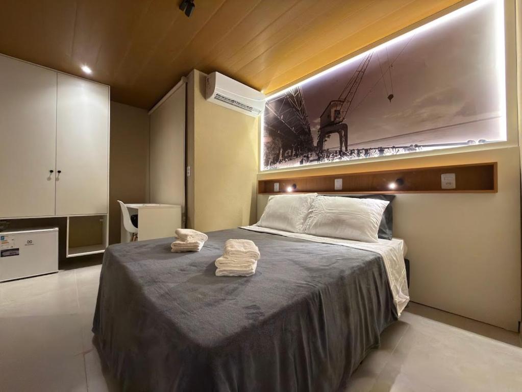 a bedroom with a bed with two towels on it at Studios 138 in Belém