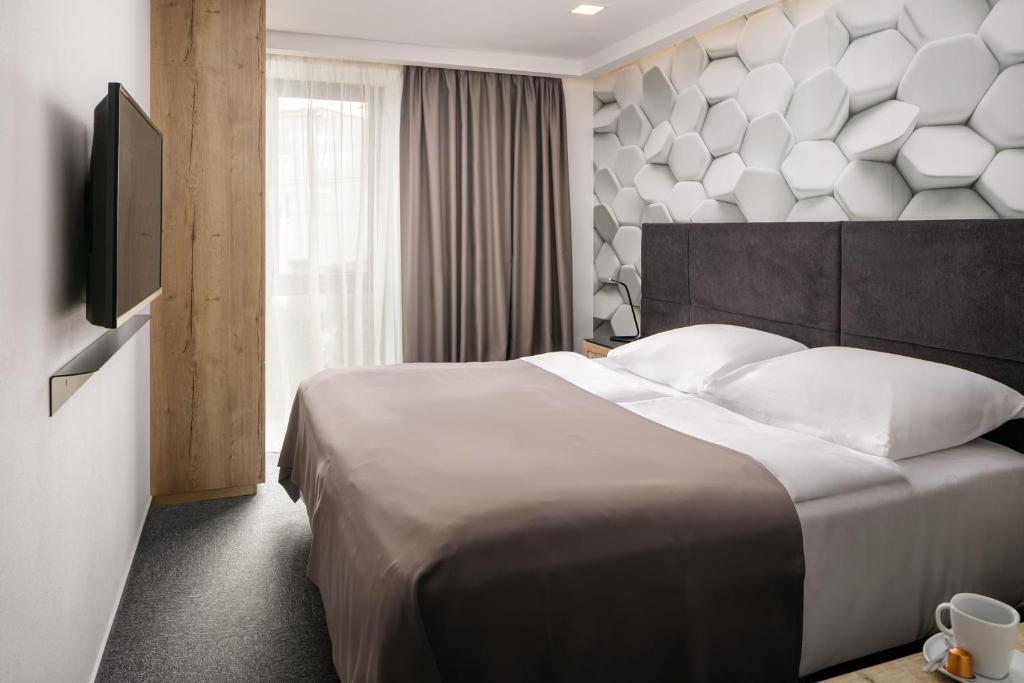 ein Hotelzimmer mit einem großen Bett und einem Fernseher in der Unterkunft 4 SMART HOTEL in Olomouc