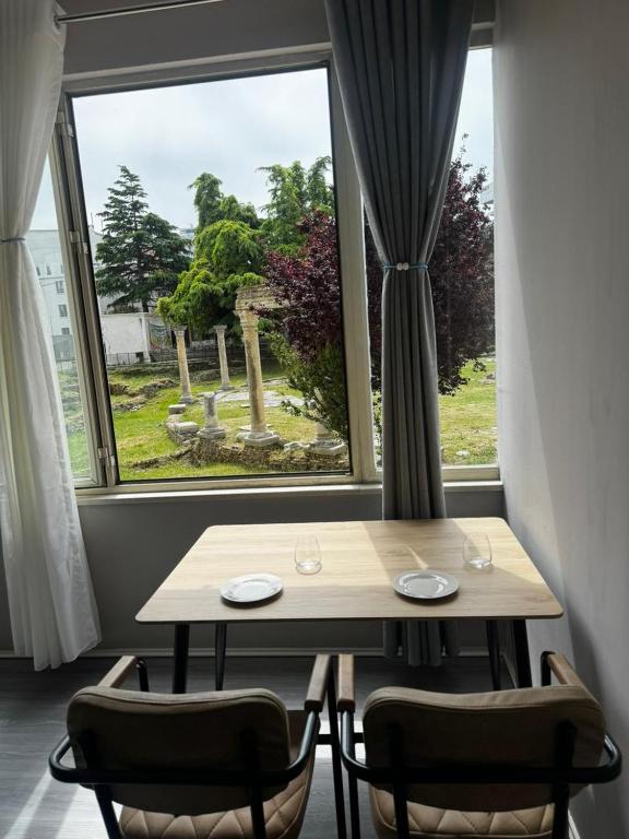 a table and chairs in a room with a window at Forum View 2 in Durrës
