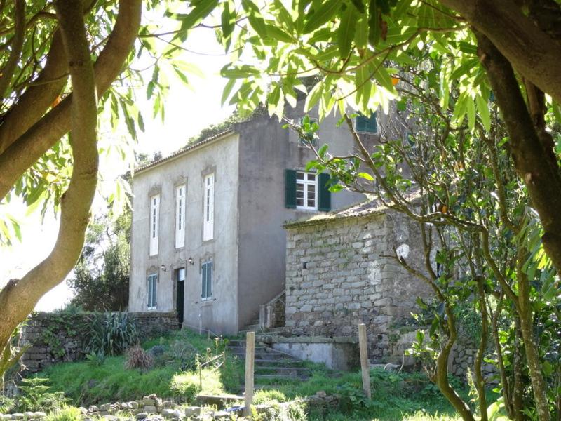 an old stone building in a field with trees at Quinta Maravista in Faial da Terra
