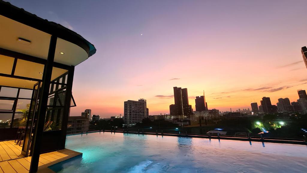 a view of a city skyline at sunset from a building at The SACHA Apart-Hotel Thonglor Sukhumvit Bangkok in Bangkok