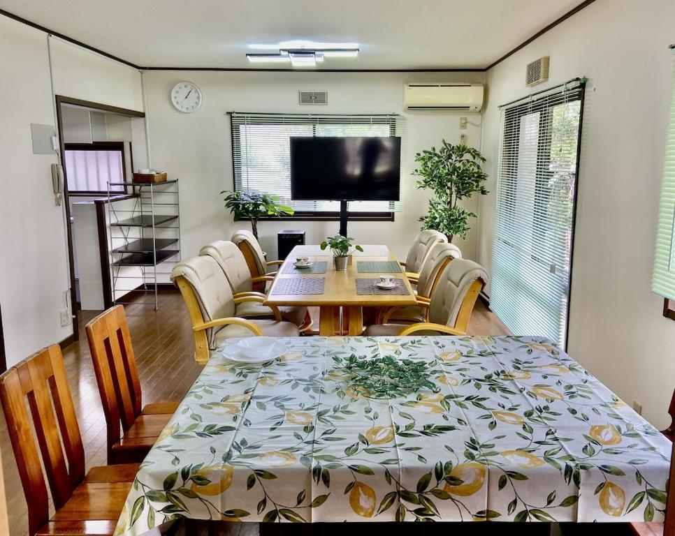 a dining room with a table and chairs and a television at ビレッジ幸 in Otsu