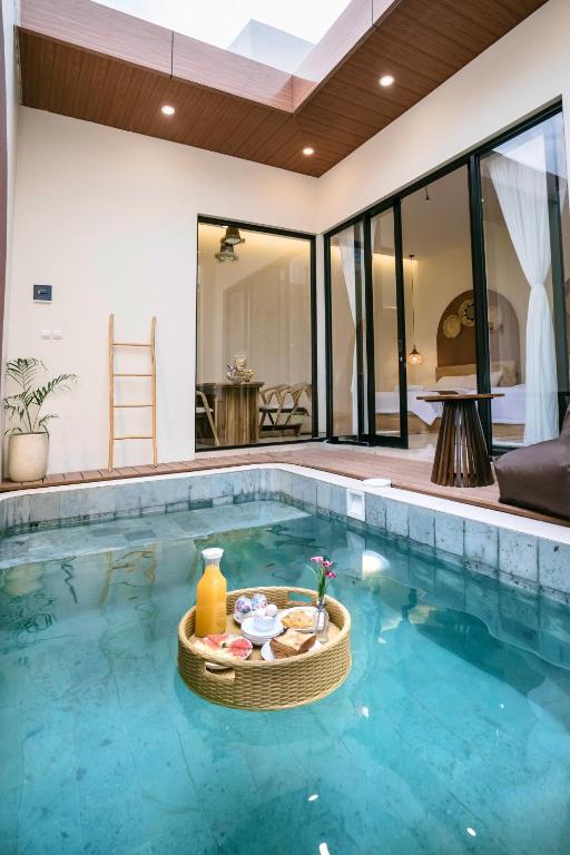 a pool with a bowl of food in the water at Palm Villa Prawirotaman in Timuran