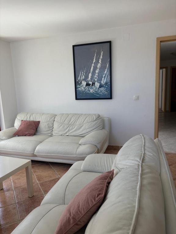 a living room with two white couches and a boat on the wall at Central nude oasis in Makarska