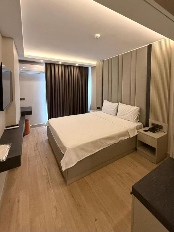 ein Schlafzimmer mit einem großen Bett und einem Fernseher in der Unterkunft Kayalar Hotel in Antalya