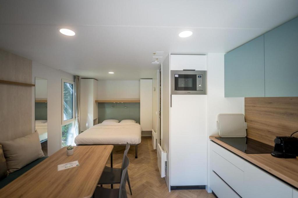 a small room with a bed and a kitchen at Urban gardens - Lodge 2p in Ieper