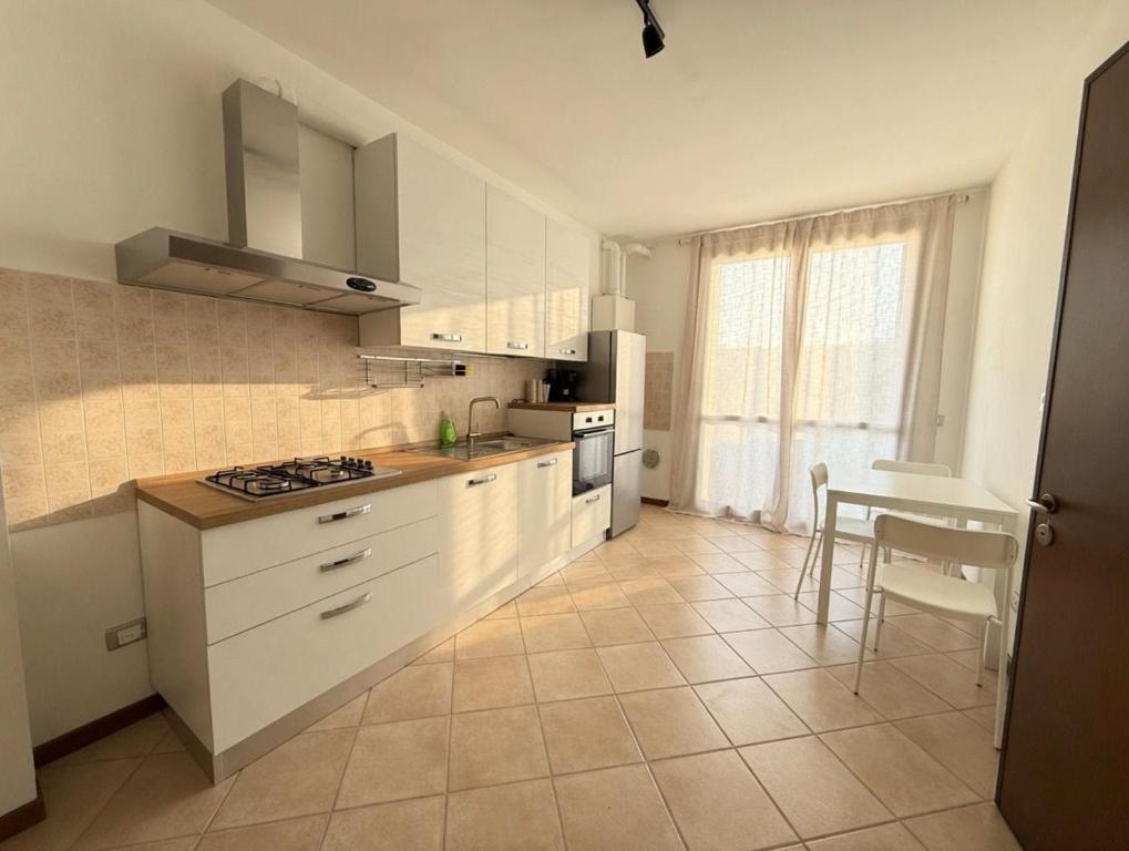 a kitchen with white cabinets and a table in it at Country Escape in Poggio Renatico