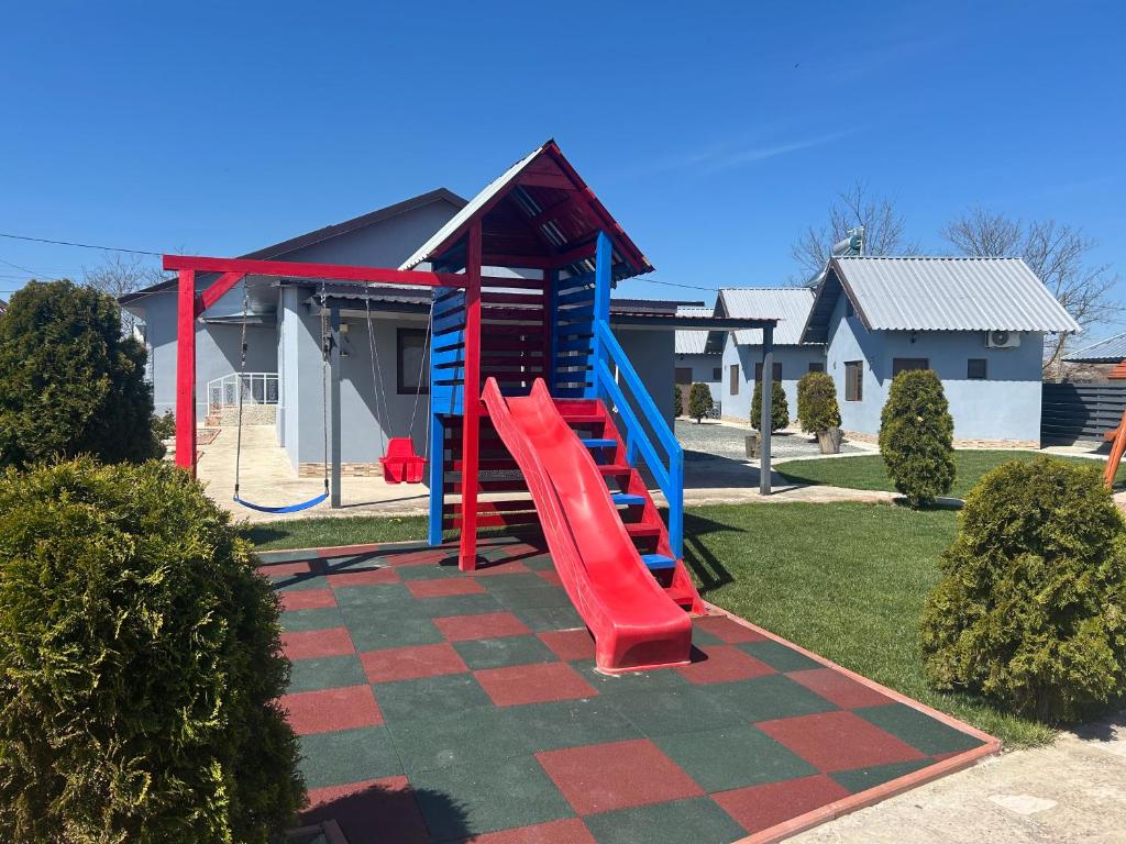 a playground with a slide in front of a house at Cazare Nicoleta in Vadu