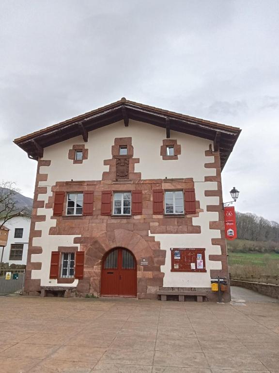 a large building with a red door on the side at Amaiurko Aterpetxea in Maya del Baztán