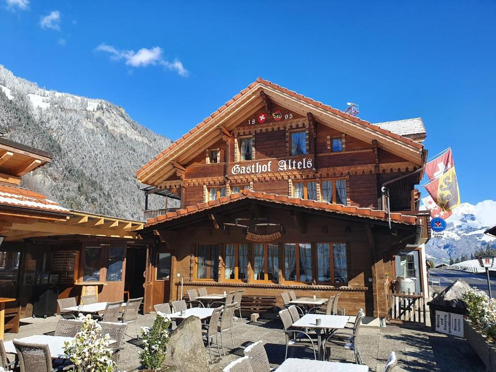 a building with tables and chairs in front of it at Hotel Altels in Kandergrund