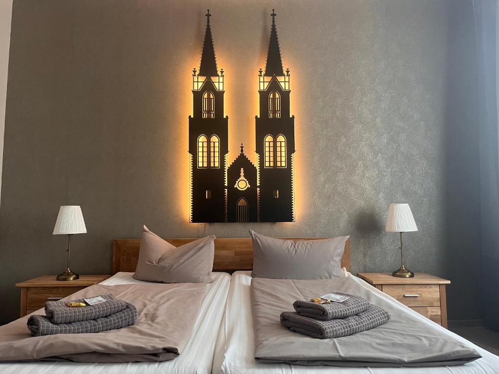a bedroom with two beds with a clock on the wall at Pension am Park in Oschatz