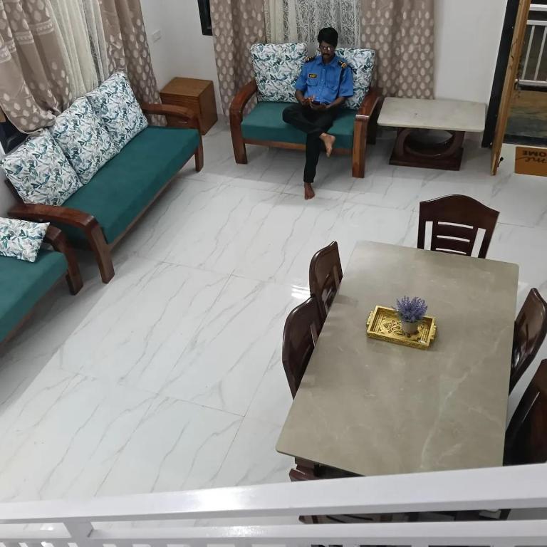 a man sitting on a couch in a living room at Shivoham holiday villa in Dapoli