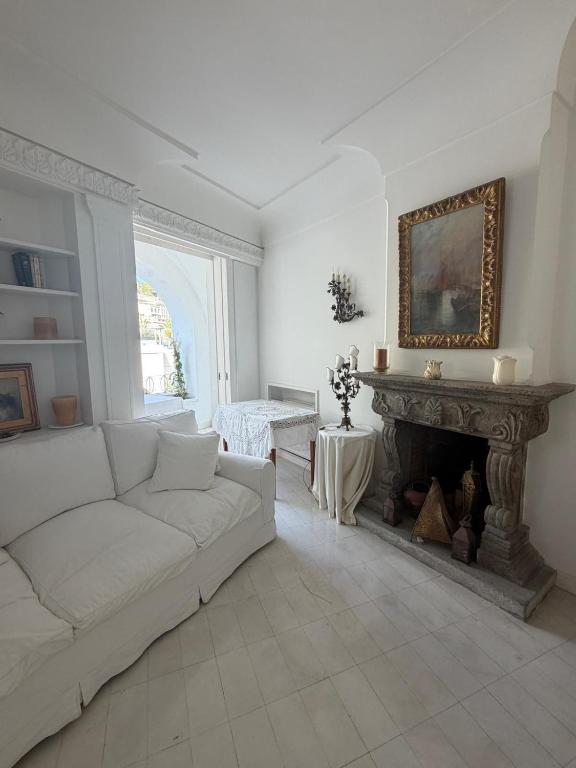 ein Wohnzimmer mit weißem Sofa und Kamin in der Unterkunft White Suite Capri in Capri