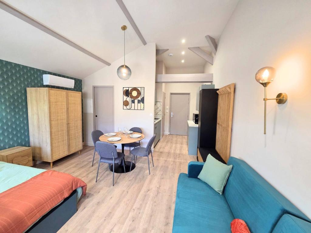 a room with a bed and a table and a couch at Le Nid Douillet Studio in Saint-Affrique