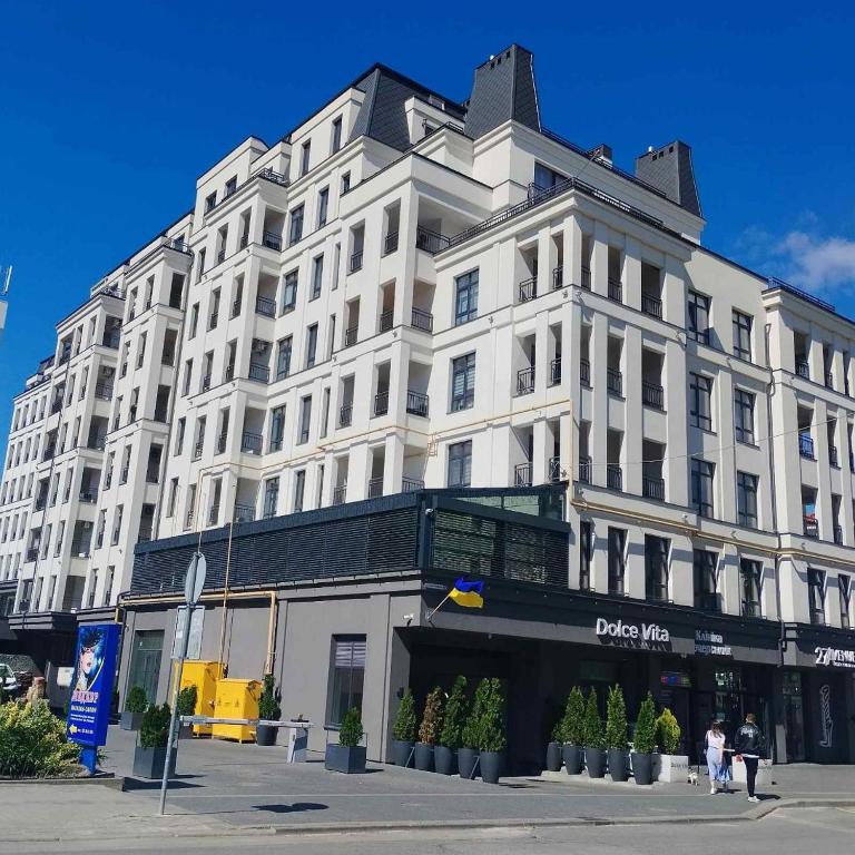a large white building with people walking in front of it at Апартаменти в ЦЕНТРІ ІМПЕРІАЛ in Truskavets