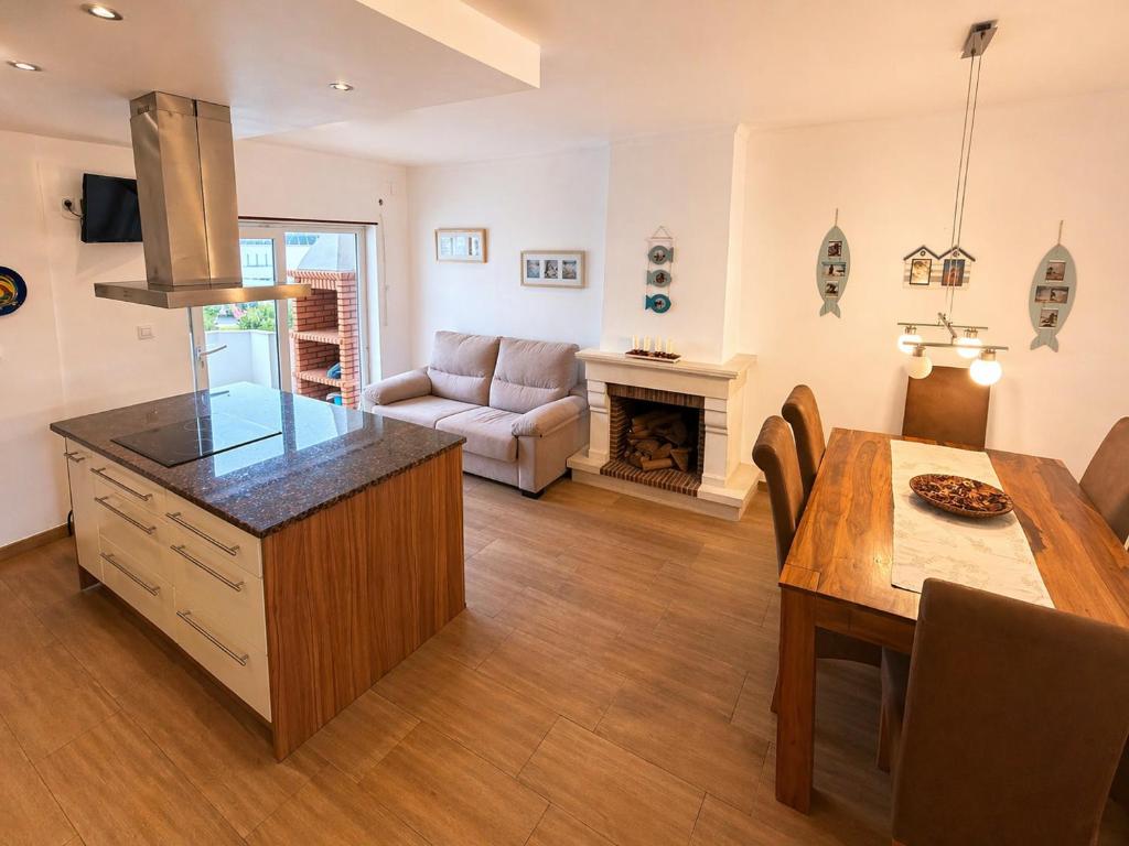 a kitchen and living room with a table and a dining room at Baleal Breeze Apartment in Ferrel