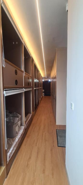 an empty room with wooden cabinets and a long hallway at CaiPods Backpacker Hostel by G10 Guest House Bandung in Bandung