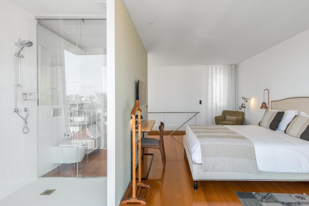 um quarto com uma cama e uma casa de banho com um chuveiro em GuestReady - Picaria Living Quarter 1 no Porto
