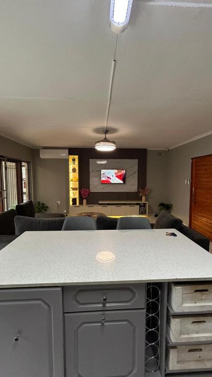 a living room with a table with chairs and a tv at TinasRose in Uvongo Beach