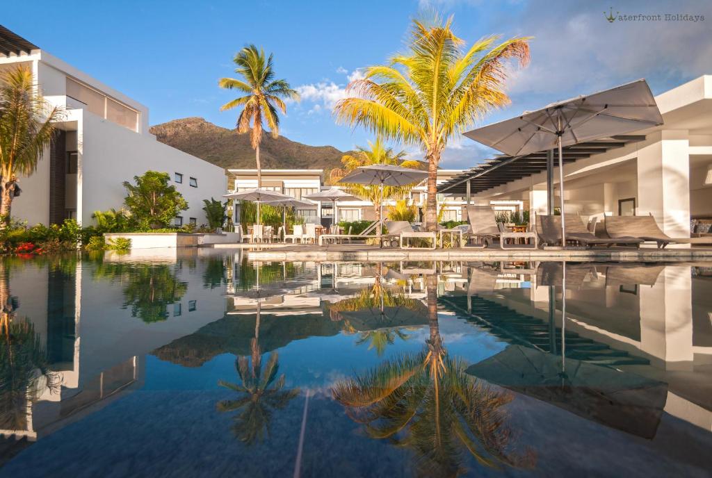 una piscina con palme e un edificio di Latitude - with private plunge pool a Rivière Noire