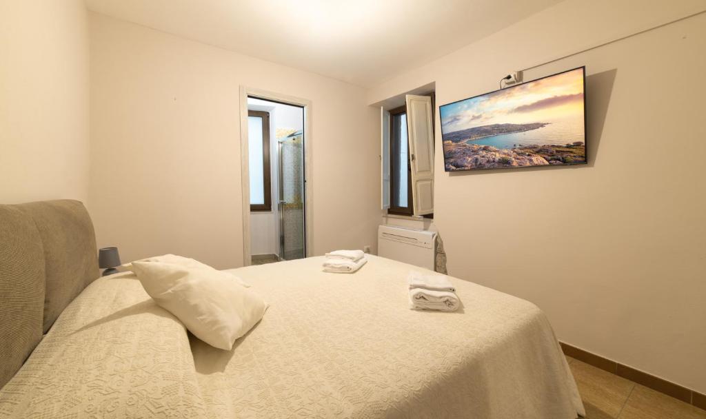 a bedroom with a bed with two towels on it at Sardinian Gallery S'Iscola in Bosa