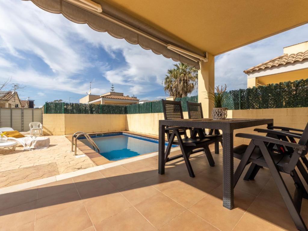 a patio with a table and chairs and a swimming pool at Holiday Home Flamenc 2 by Interhome in Riumar