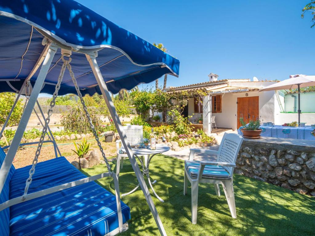 a patio with a table and chairs and an umbrella at Holiday Home Can Niu by Interhome in Pollença