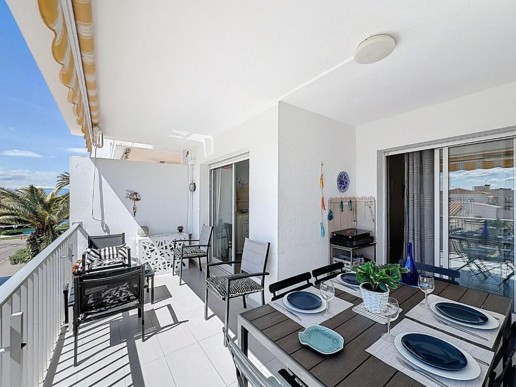 a living room with a table and chairs on a balcony at Apartment Pattaya-8 by Interhome in Empuriabrava