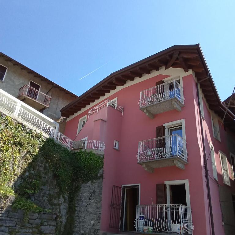a pink building with white balconies on it at Casa Carlotta in Perledo