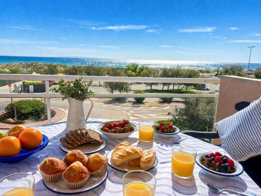 a table with breakfast food on a table with a view at Apartment Port Pals Summer Vibes by Interhome in Pals