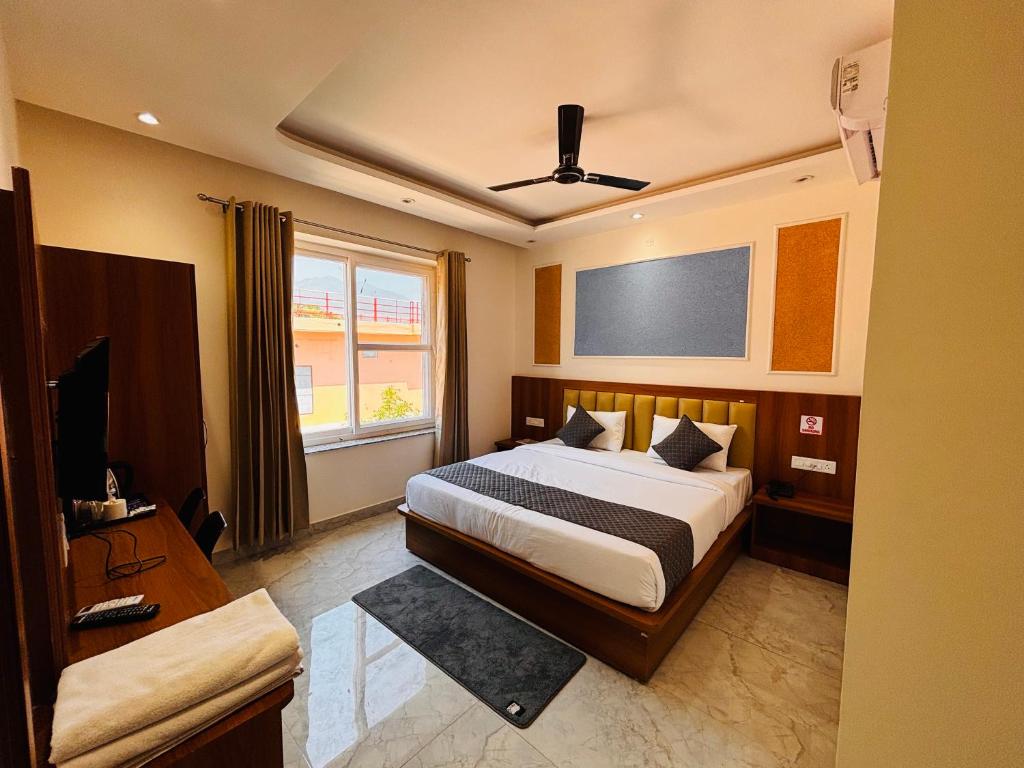 a bedroom with a bed and a flat screen tv at Hotel shivay palace in Rishīkesh