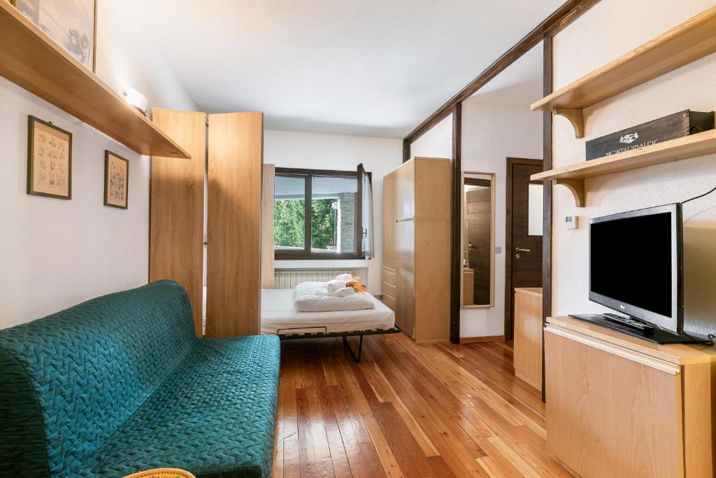 a living room with a green couch and a television at Grange Studio - Happy Rentals in Grange Sises