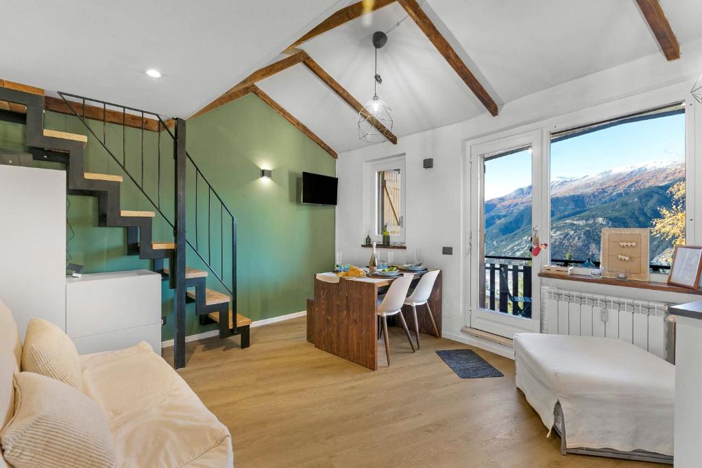 a living room with a staircase and a room with a table at La Chicchetta - Happy Rentals in Sauze d'Oulx