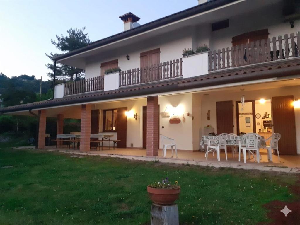 a house with a patio and a table and chairs at ROSSO DI SERA Bed & Breakfast in Tarcento