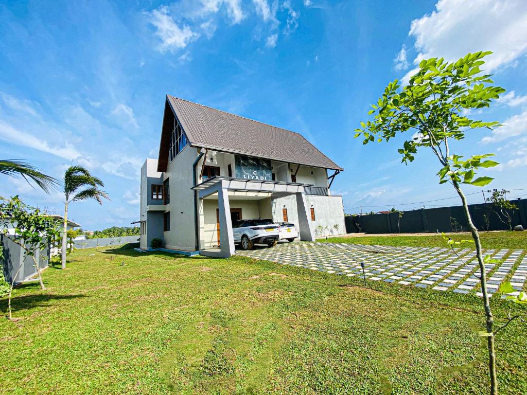 a house with a car parked in front of it at Liyadi Addalaichenai in Addalachenai