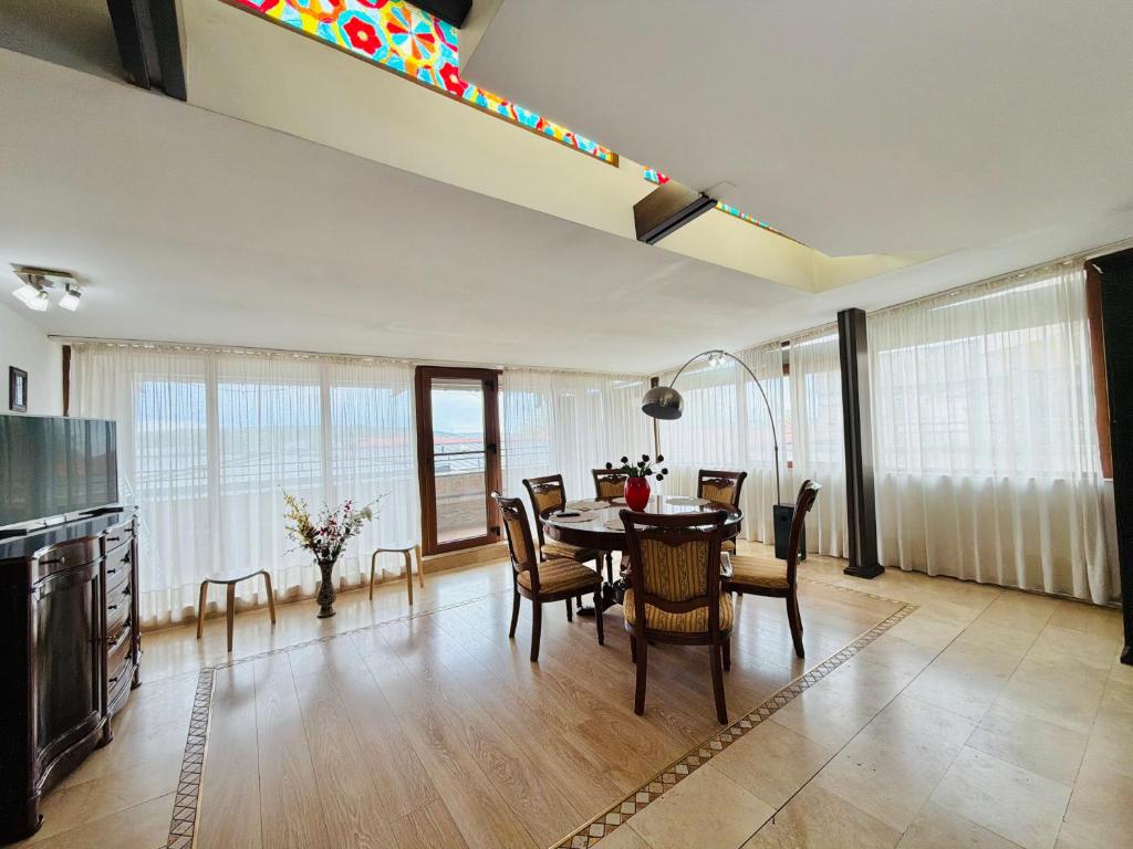 a kitchen and dining room with a table and chairs at Spacious Apartment in City Centre in Iaşi