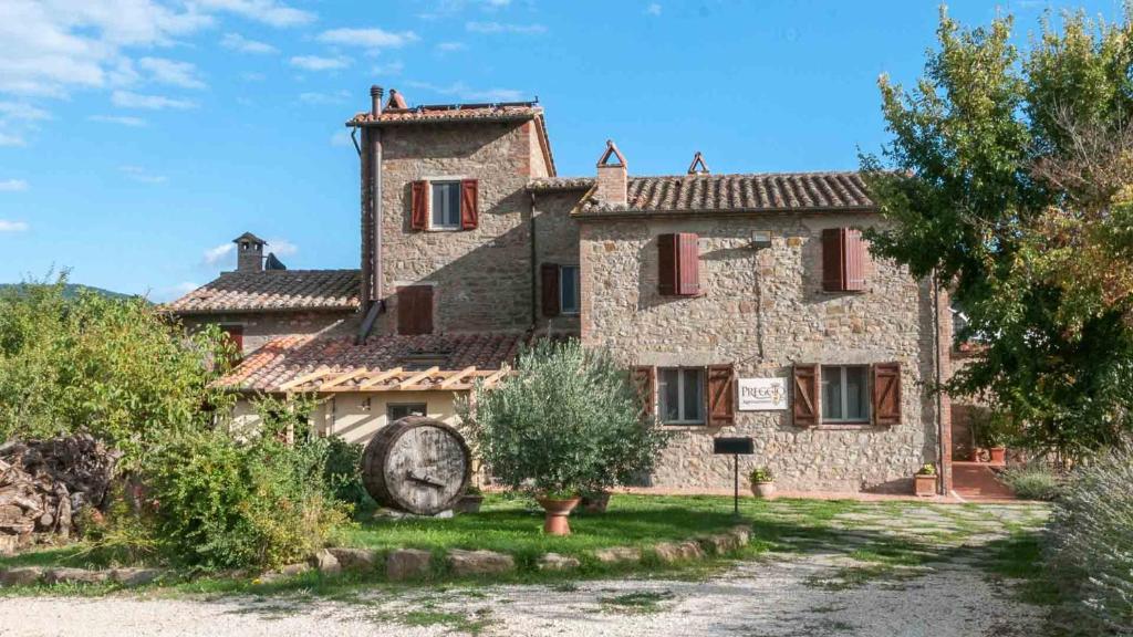 an old stone house with a clock in front of it at Agriturismo Preggio in Umbertide