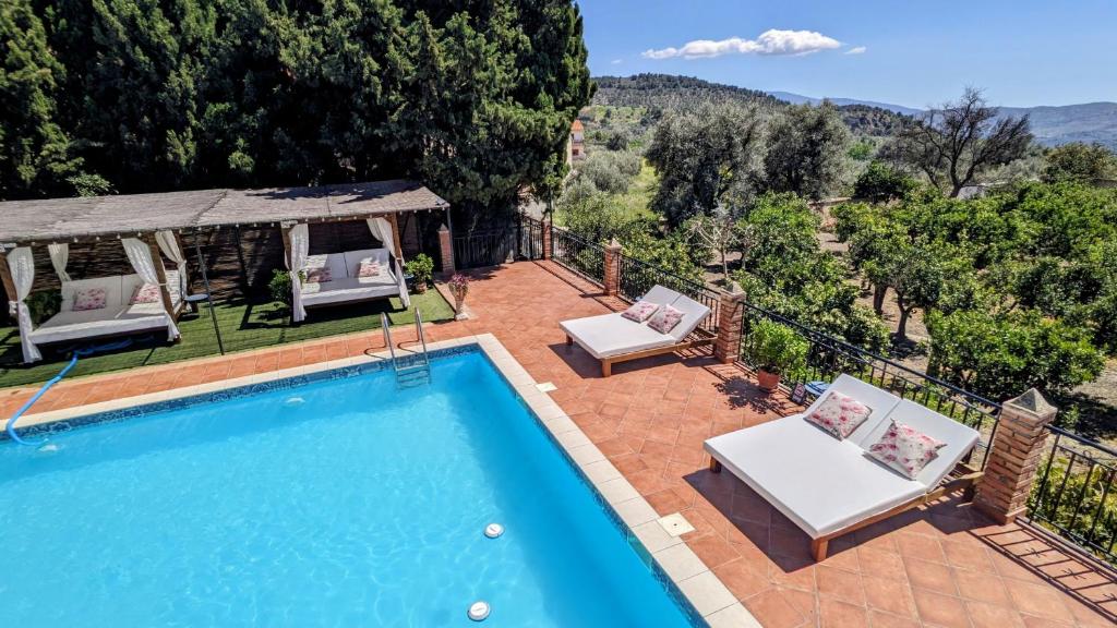 a swimming pool with two chairs and a gazebo at La Cañota Suite King Rooms Adults Only in Talara