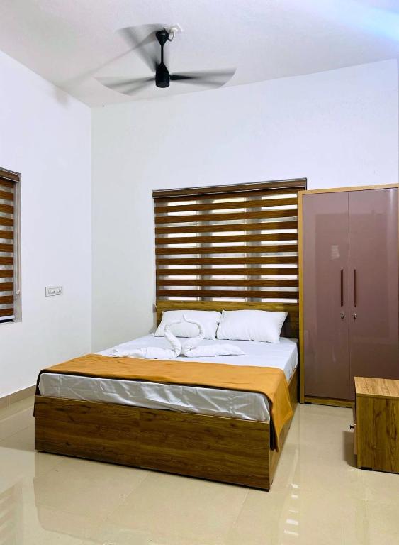 a bedroom with a bed with a wooden headboard at Easy Nest Kannur in Valapattanam