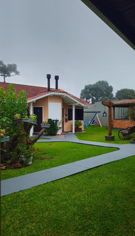 a house with a garden and a playground at Pousada Gramadense in Gramado