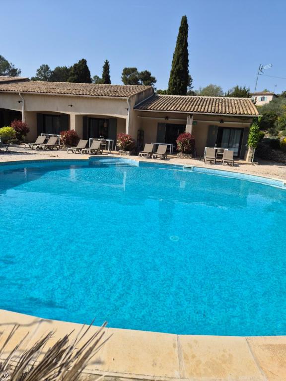 una grande piscina blu davanti a una casa di La Cigale a Les Arcs-sur-Argens